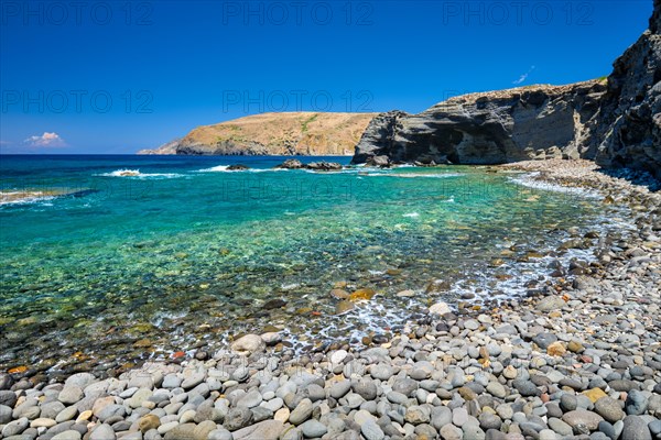 Papafragas beach with crystal clear turquoise water and tunnel rock formations in Milos island