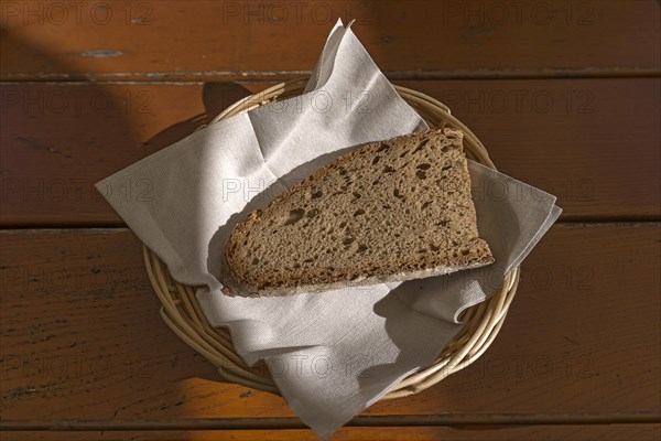 A slice of bread in a bread basket with napkin