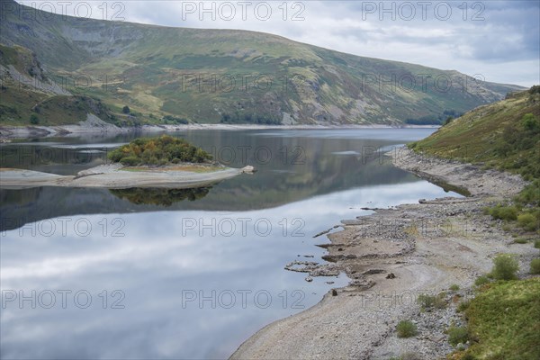 View of upland reservoir with low water level and remains of submerged village exposed after a dry summer
