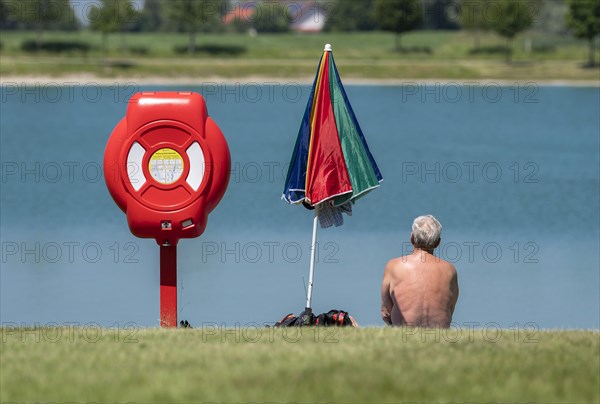 A man sits on the bank of the Kronthaler Weihers in Erding
