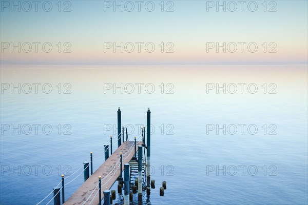 Abendstimmung ueber dem Bodensee mit Badesteg zum See