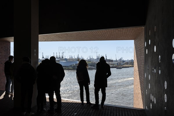 Visitors standing at the window of the public viewing platform