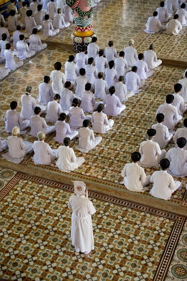 Caodaist disciples sitting during ceremony