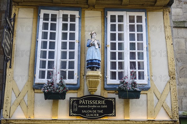 Half-timbered house of a pastry shop with statue of a woman in historical traditional costume in the Rue Kereon