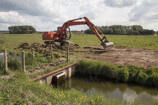 Use of an excavator for maintenance work on the lock gate at Deepdale Marsh in north Norfolk