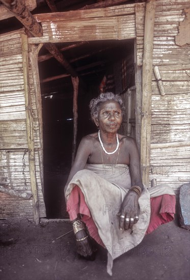 Mudunga tribal old lady sitting in front of the hut a tribal village near Silent Valley