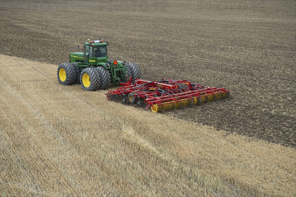 John Deere 9400 pulling Vaderstad TopDown 700 cultivator and tilling stubble field