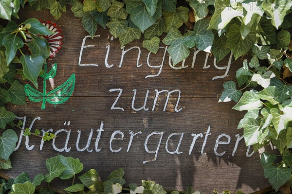 Handgeschriebenes Schild Eingang zum Kraeutergarten