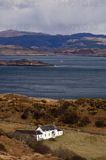 View of coastline and remote farmhouse