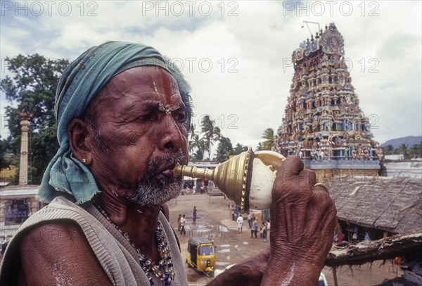 Sadhu blowing conch standing infornt of Nataraja temple in Perur near Coimbatore