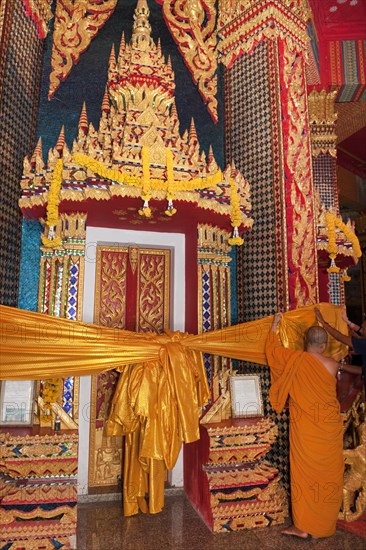 Monk attaches Songkran temple decoration