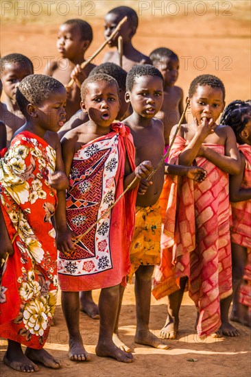 Children watch with interest at traditional customs in real African village