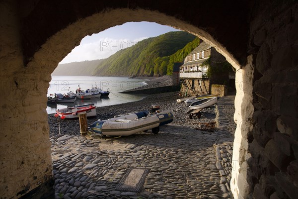 View through archway of fishing boats and wharf houses at dawn