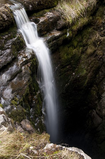 High mountain stream flowing into the abyss