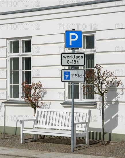 Traffic sign for temporary parking in front of white house wall
