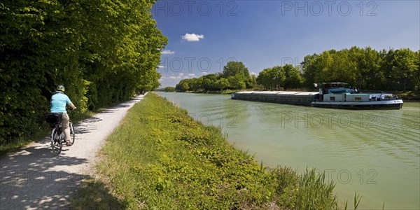 Panorama with cyclist and Dortmund-Ems Canal with cargo ship