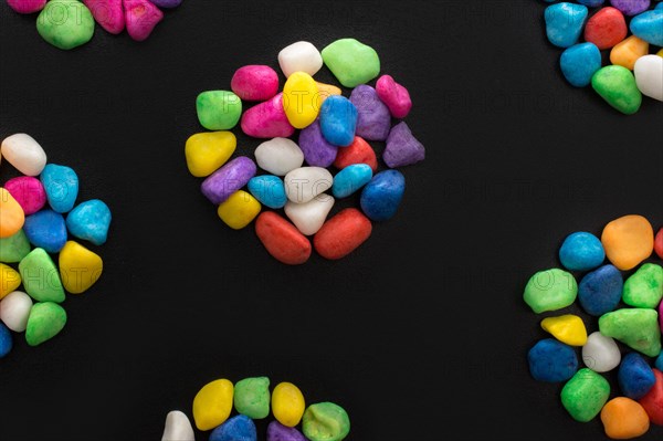 Pile of little colorful pebbles on black background