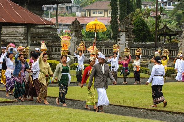 Procession of Hindu worshippers walking with offerings to temple