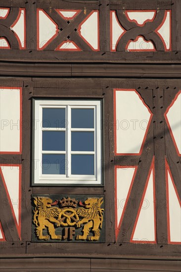 Wood carving with lion figures and pretzel on half-timbered house