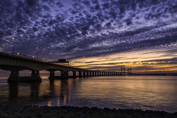 View of road bridge over river at sunset