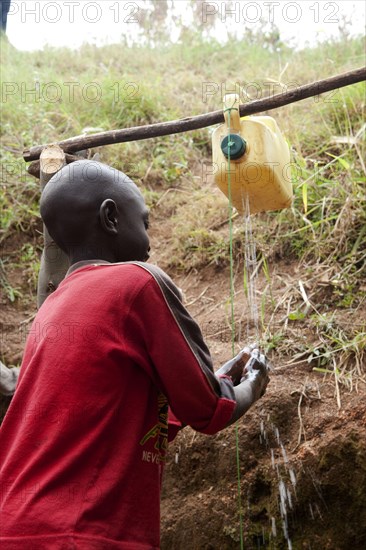 Child washes hands under self-made tap