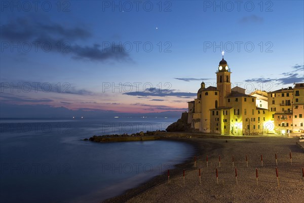 View of coastal village with church and beach at night