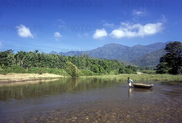 A man pulling the coracle on the Bhavani river in Attappadi