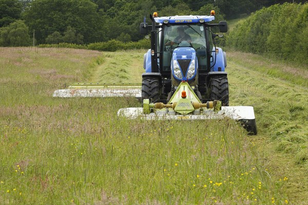 Contractor with New Holland T6080 tractor with front and rear mounted Claas mowers