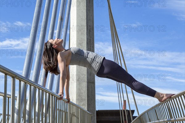 Reverse plank yoga pose performed on a bridge