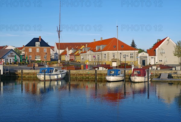 Leisure boats and houses in a small harbour in the evening light