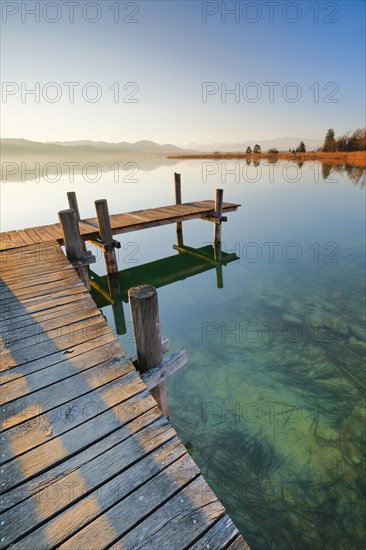 Holzsteg am Pfaeffikersee bei Sonnenaufgang mit Blick zum Bachtel und Glaernisch im Hintergrund