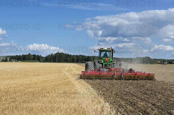 John Deere 9400 pulling Vaderstad TopDown 700 cultivator and tilling stubble field