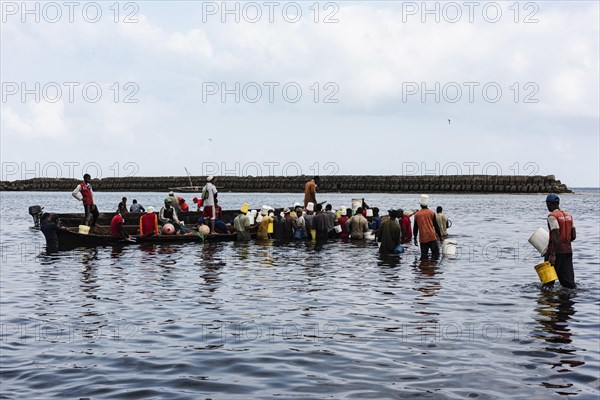 Fischer und Fischhaendler im Wasser am Fischereihafen