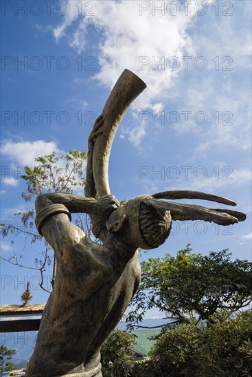 Tribal man statue blowing a horn