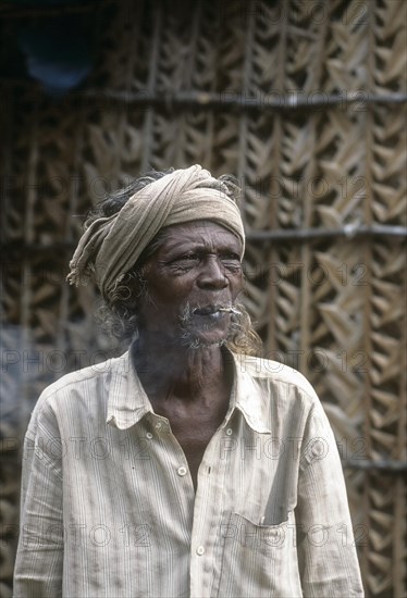 A Kurumba Tribal man smoking beedi