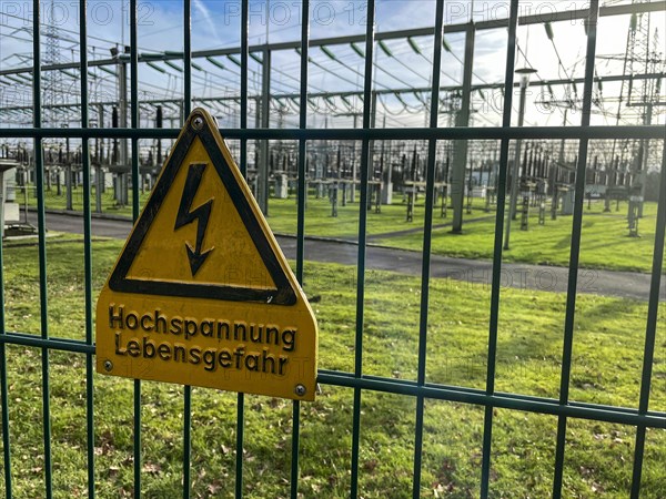 Warnschild Hochspannung Lebensgefahr an Sicherheitszaun von Umspannwerk fuer Stromversorgung