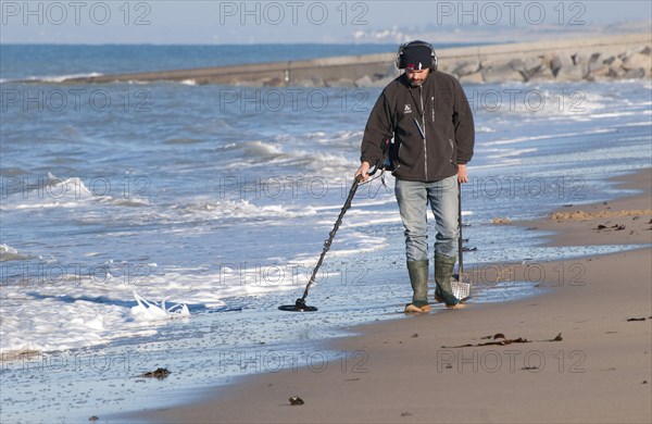 Man using metal detector on beach