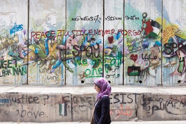 A young Palestinian woman at the wall in the West Bank
