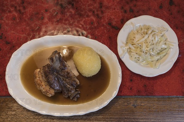 Schaeufele with dumpling and coleslaw served in a Franconian inn