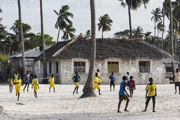 Jungen spielen Fussball im Dorf Jambiani