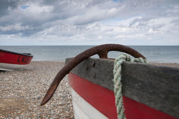 Close-up of anchor in fishing boat on shingle beach