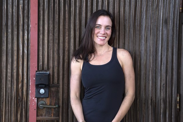 Smiling attractive woman in fornt of wooden door