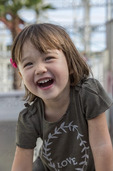 Amused three year old girl at the amusement park in San Diego