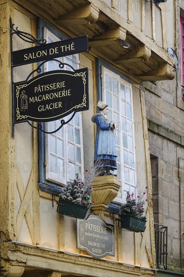 Half-timbered house of a pastry shop with statue of a woman in historical traditional costume in the Rue Kereon