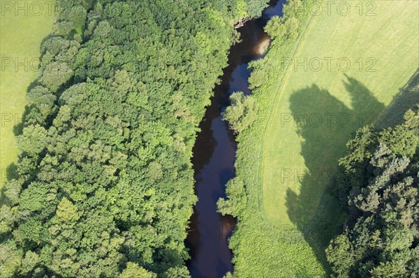 Aerial view of a river surrounded by woodland and flowing through farmland