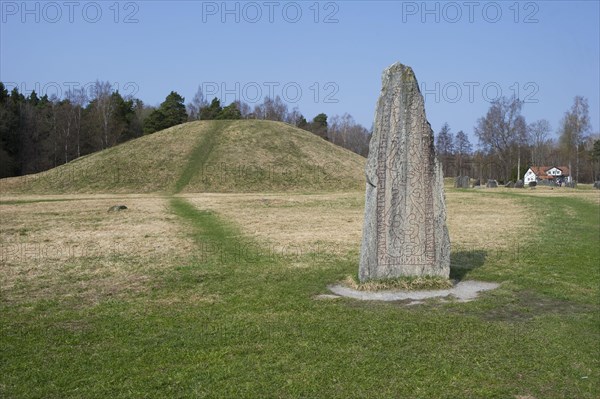 Rune stone beside ancient tumulus