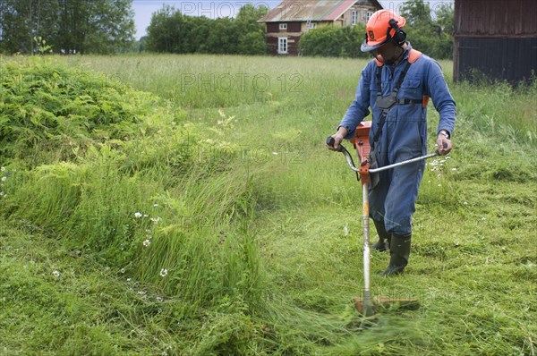 Man with strimmer on the farm