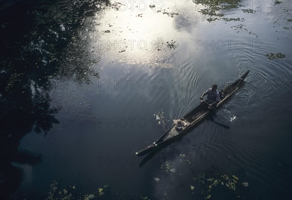 Fisherman in a small wooden boat