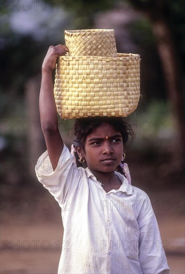Village girl carrying basket on head