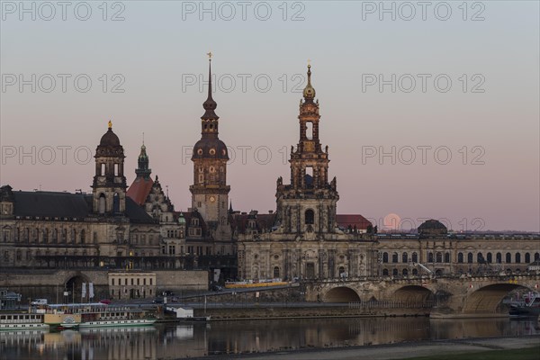 Sunrise and full moon behind the silhouette of the old town with the towers of the Staendehaus